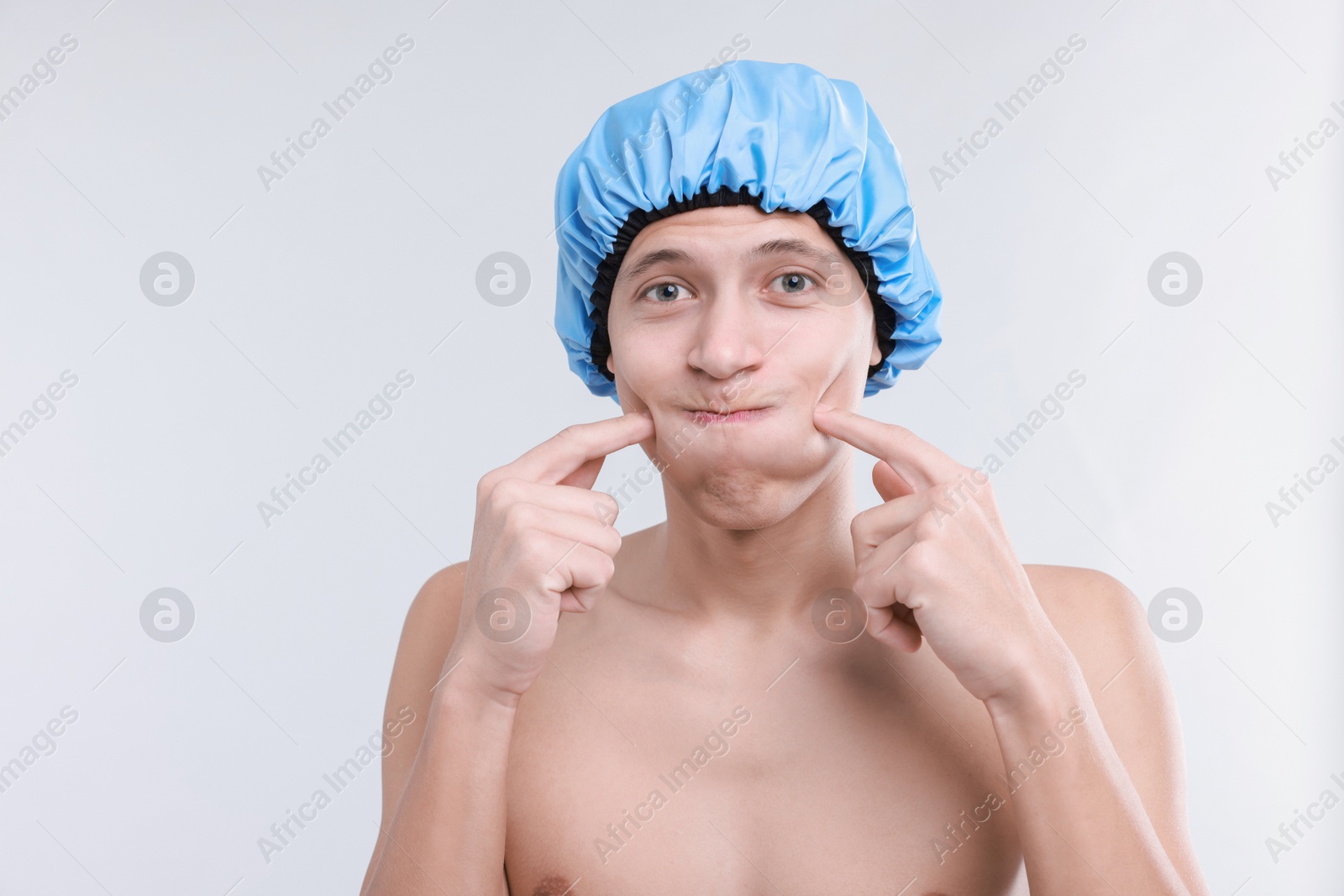 Photo of Man in shower cap on light grey background