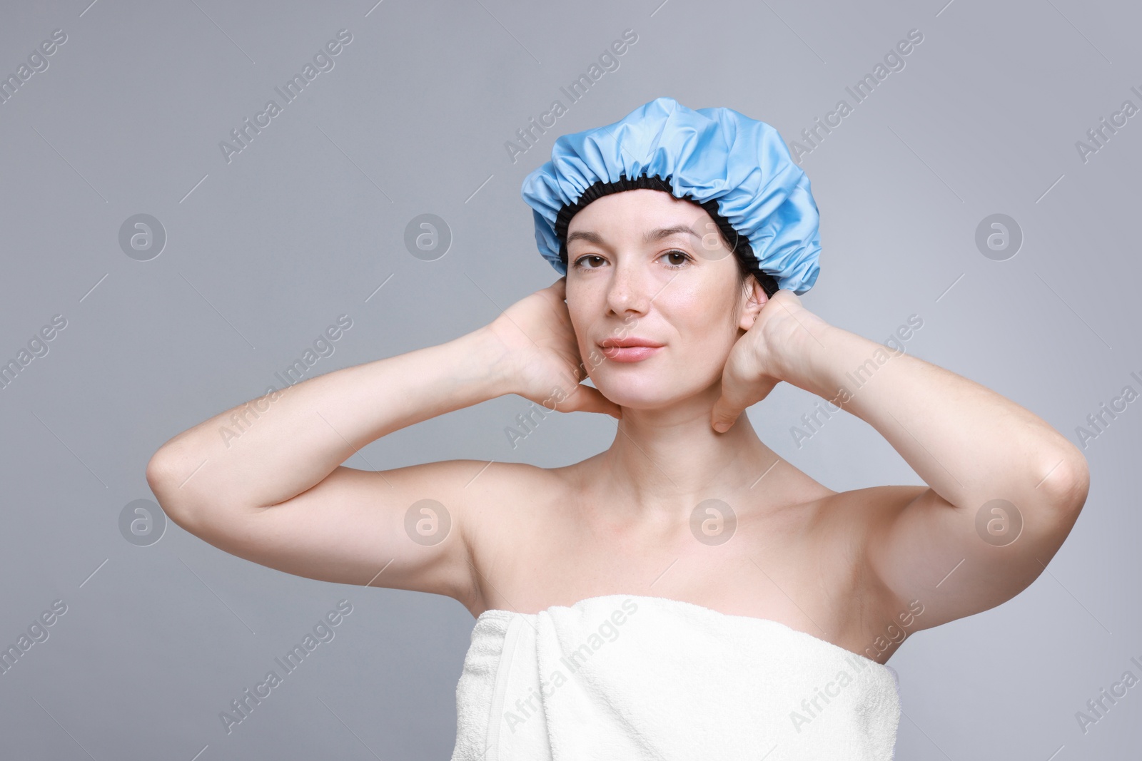 Photo of Woman wearing shower cap on grey background