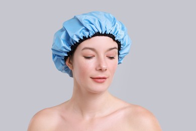 Woman in shower cap on grey background