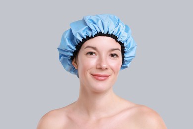 Woman in shower cap on grey background