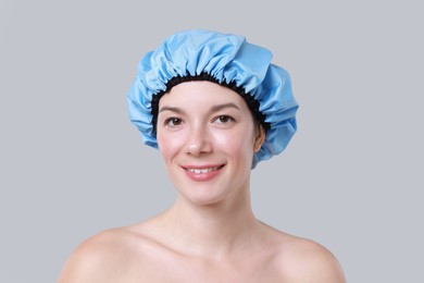 Woman in shower cap on grey background