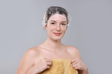 Woman in shower cap on grey background