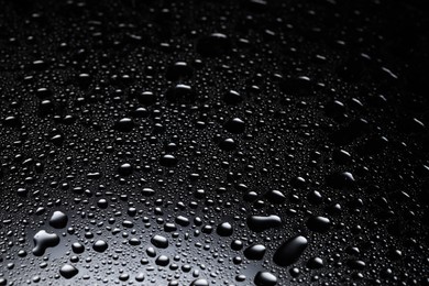 Water drops on dark glass surface, closeup