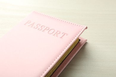 Photo of Passport in pink cover on white wooden table, closeup