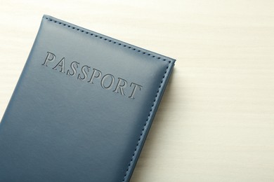 Photo of Passport in grey cover on white wooden table, top view. Space for text