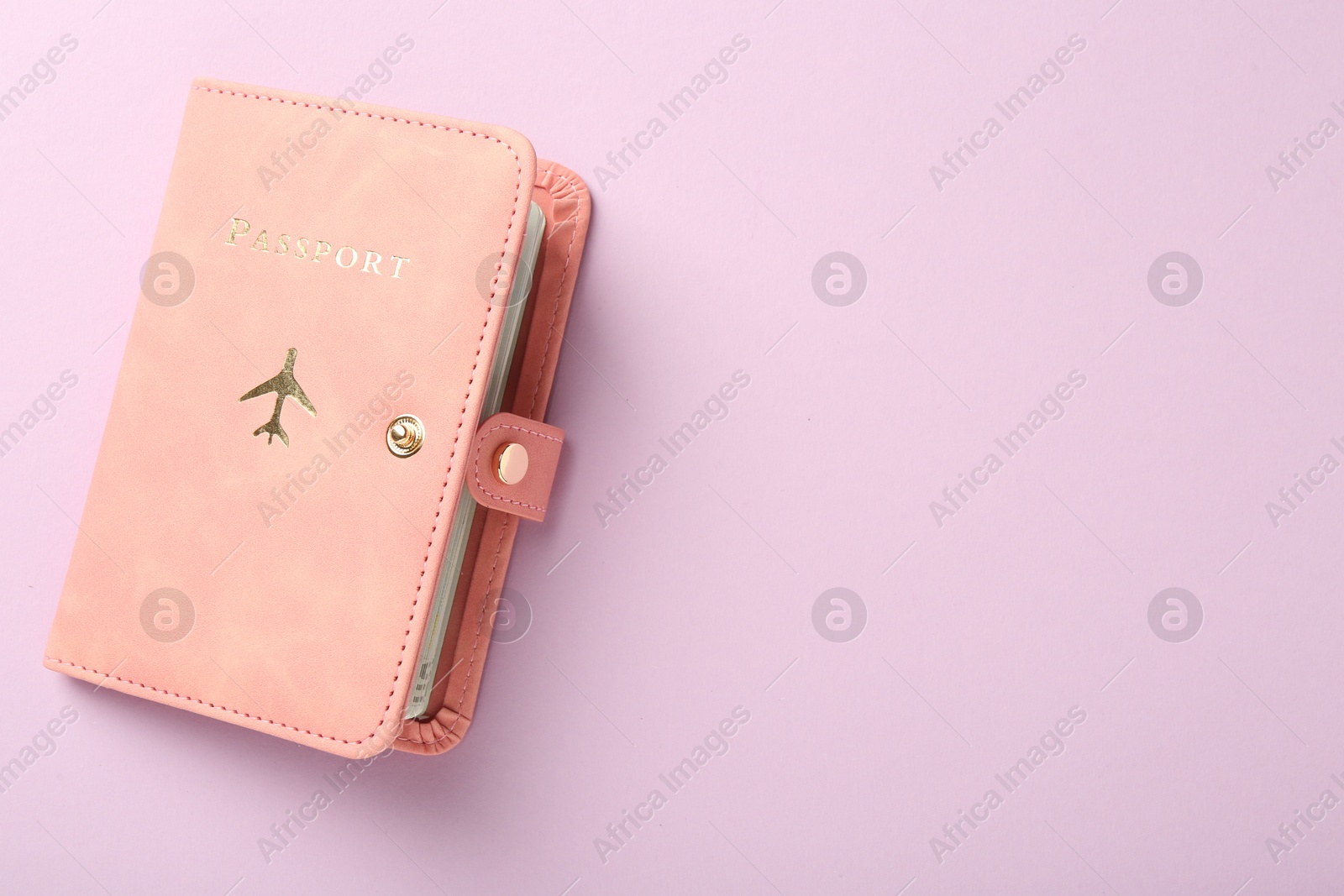 Photo of Passport in pink cover on violet background, top view. Space for text