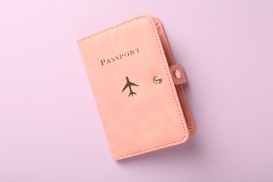 Photo of Passport in pink cover on violet background, top view