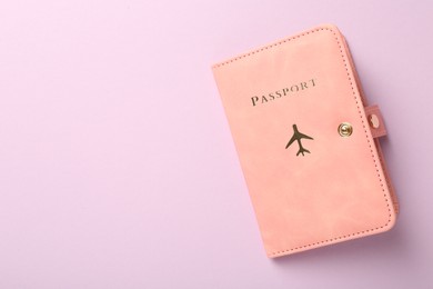 Photo of Passport in pink cover on violet background, top view. Space for text