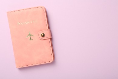 Photo of Passport in pink cover on violet background, top view. Space for text