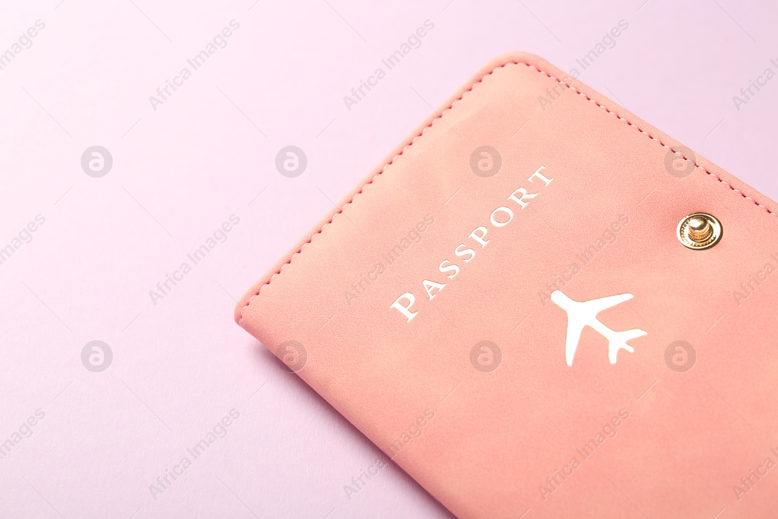 Photo of Passport in pink cover on violet background, closeup. Space for text