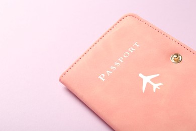 Photo of Passport in pink cover on violet background, closeup. Space for text