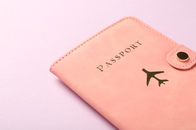 Photo of Passport in pink cover on violet background, closeup