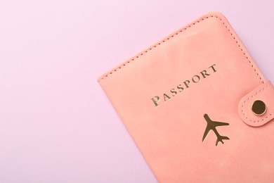 Photo of Passport in pink cover on violet background, top view. Space for text