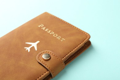 Photo of Passport in brown cover on turquoise background, closeup