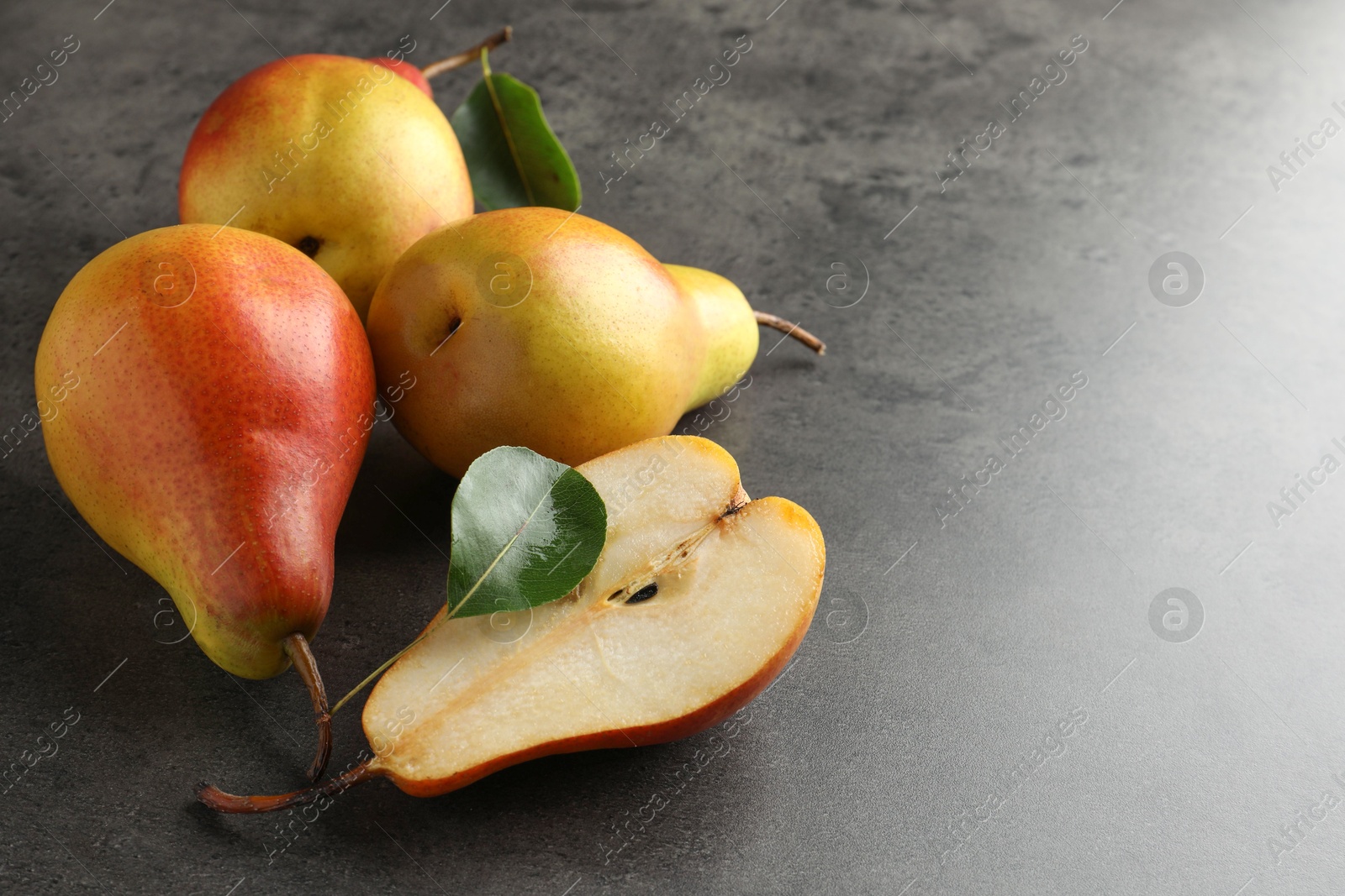 Photo of Ripe juicy pears on grey table, closeup. Space for text