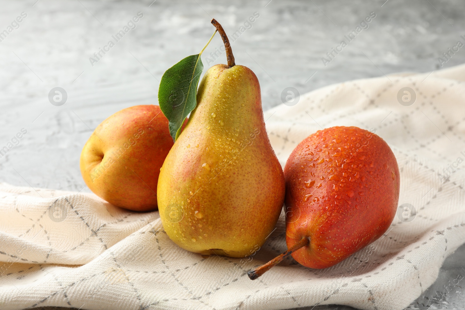 Photo of Ripe juicy pears on grey table, closeup