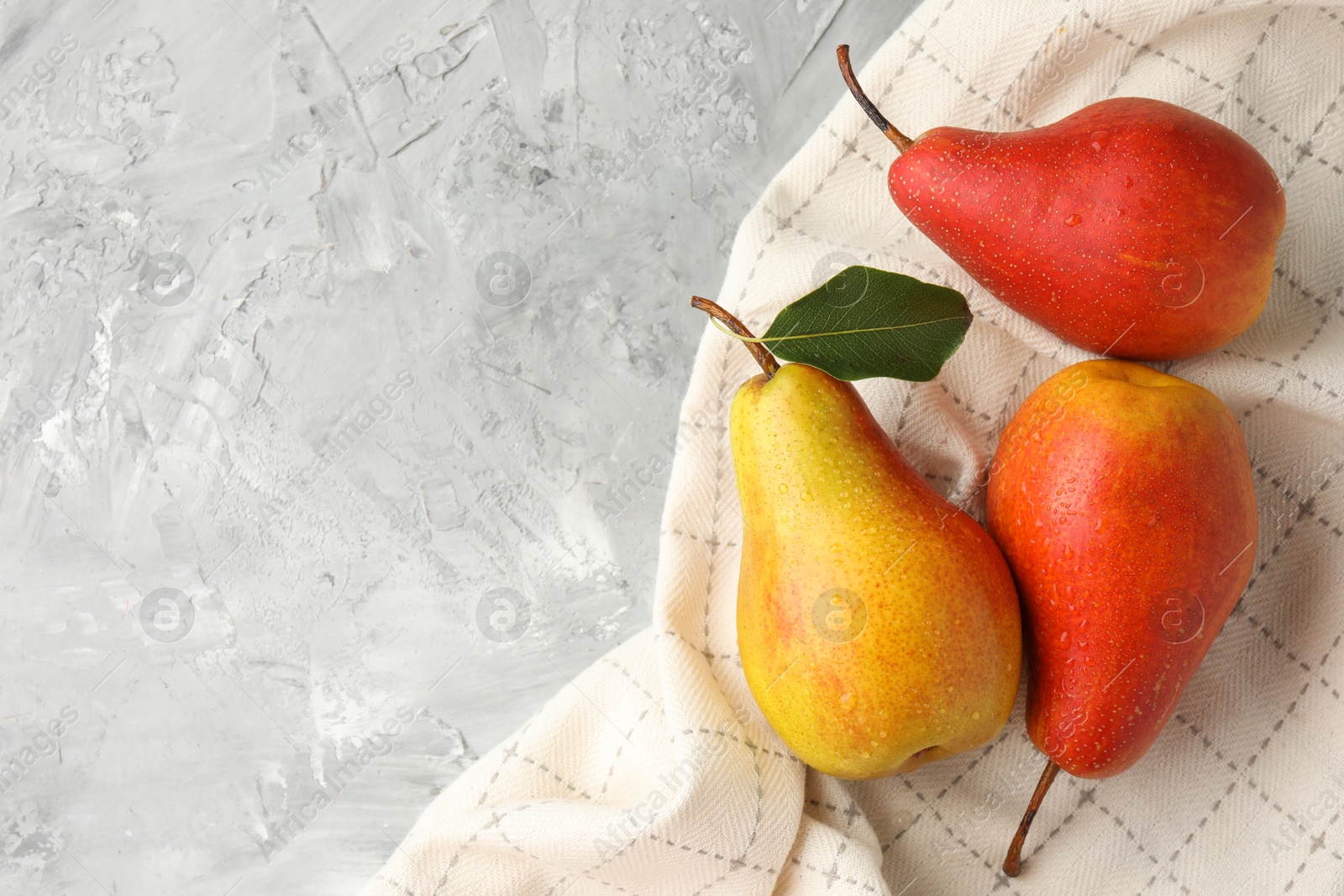 Photo of Ripe juicy pears on grey table, flat lay. Space for text