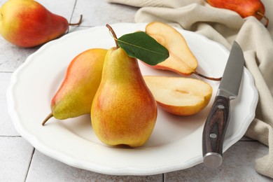 Photo of Ripe juicy pears on light tiled table, closeup