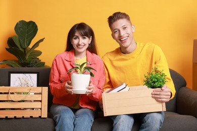 Happy couple with different stuff in new apartment. Housewarming party