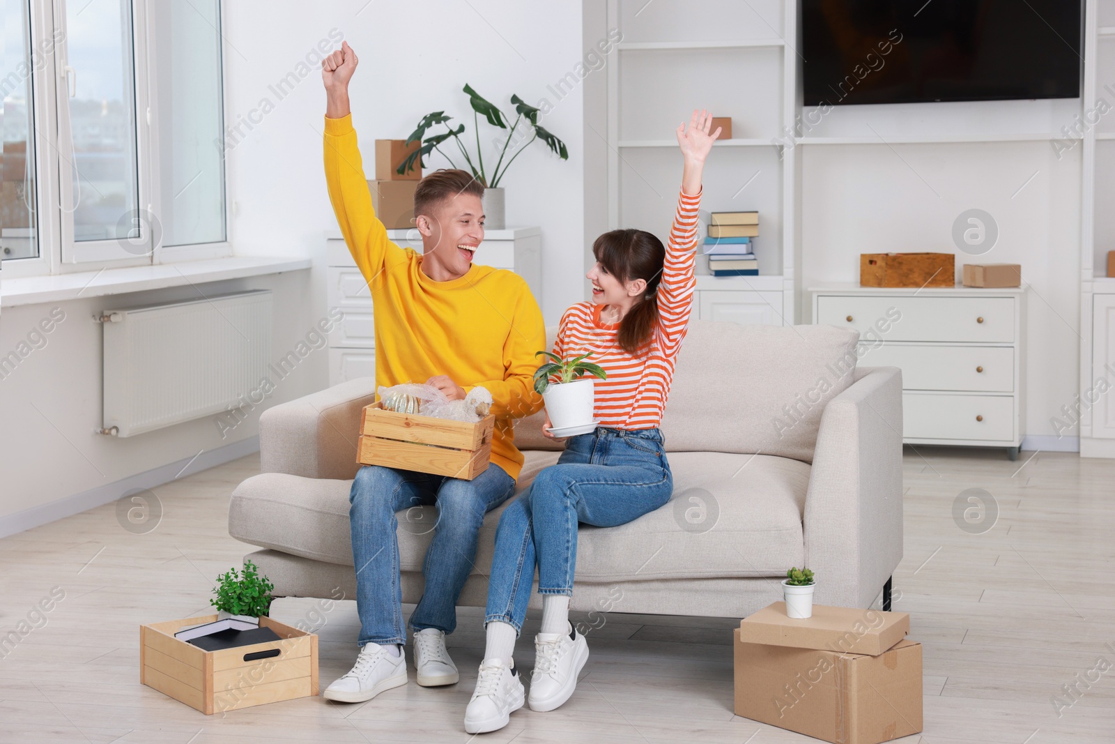 Photo of Happy couple with different stuff in new apartment. Housewarming party