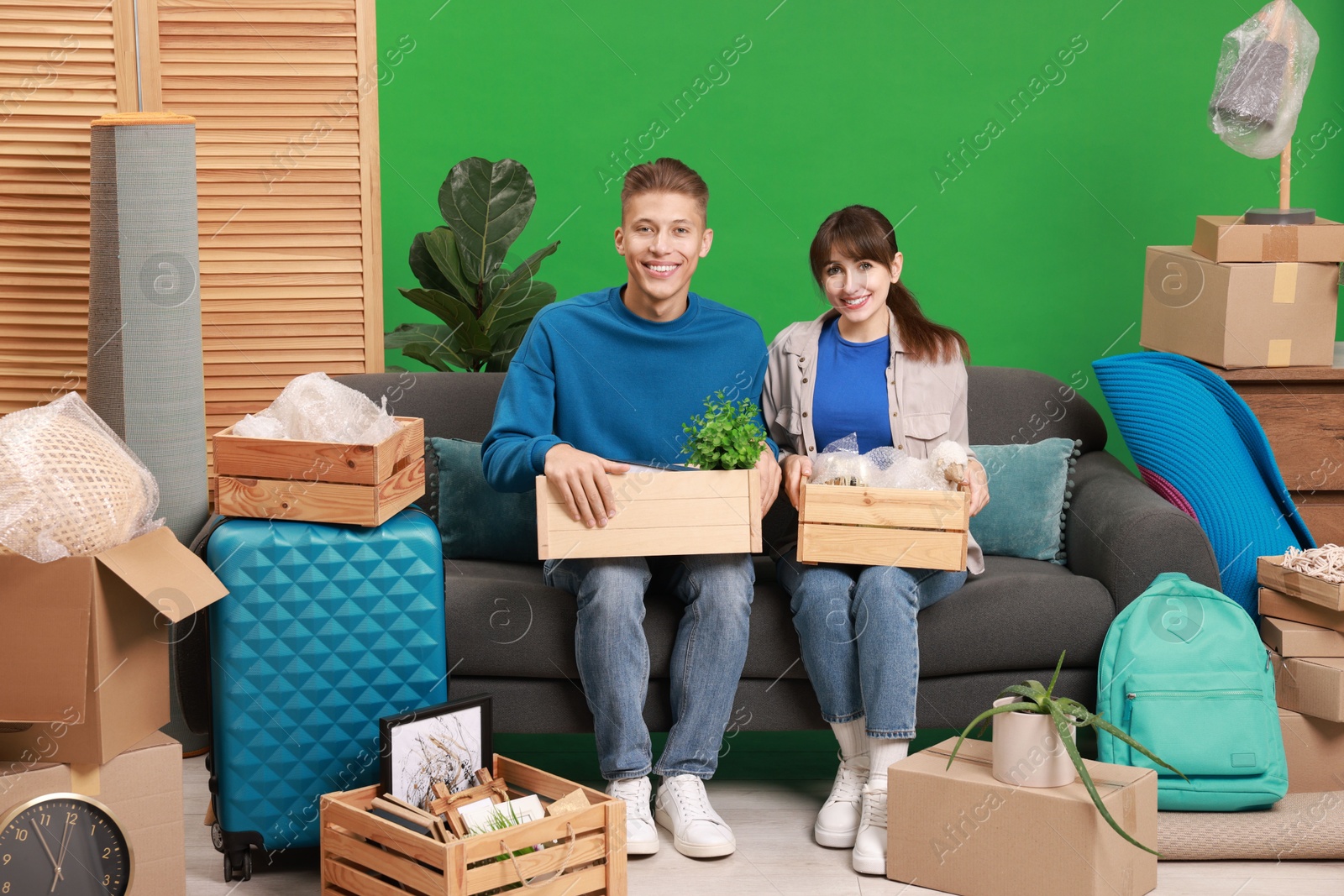 Photo of Happy couple with different stuff in new apartment. Housewarming party