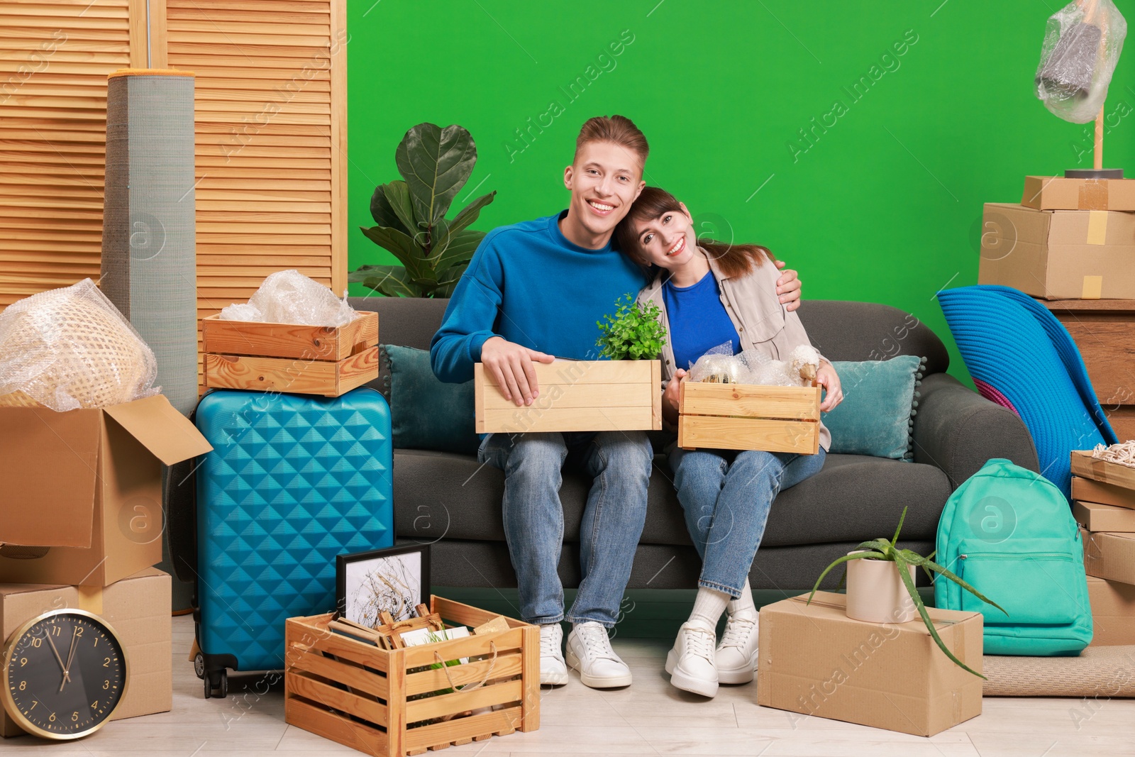 Photo of Happy couple with different stuff in new apartment. Housewarming party