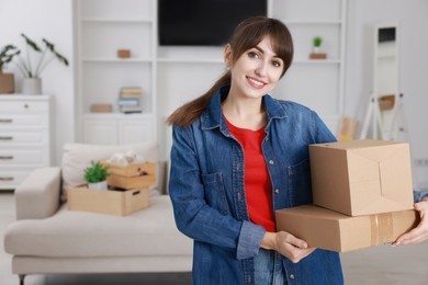 Happy woman with moving boxes in new apartment. Housewarming party