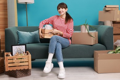 Photo of Happy woman with moving boxes in new apartment. Housewarming party