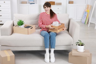 Happy woman with moving boxes in new apartment. Housewarming party