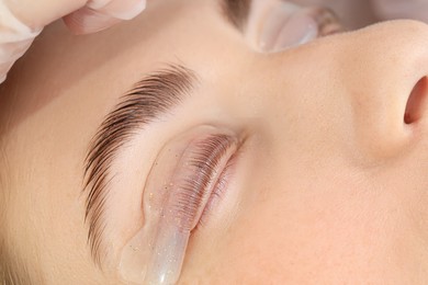 Photo of Woman undergoing eyelash laminating procedure in beauty salon, closeup