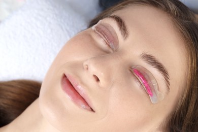 Photo of Woman undergoing eyelash laminating procedure in beauty salon, closeup