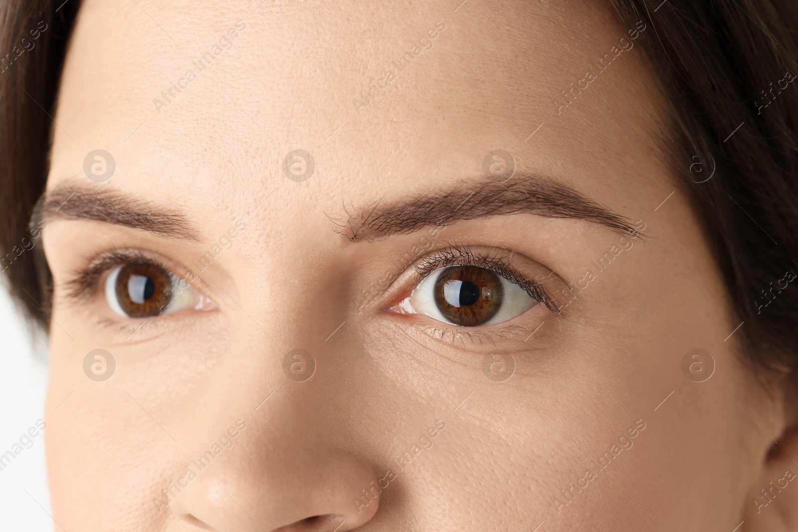 Photo of Woman with beautiful eyes on light background, closeup