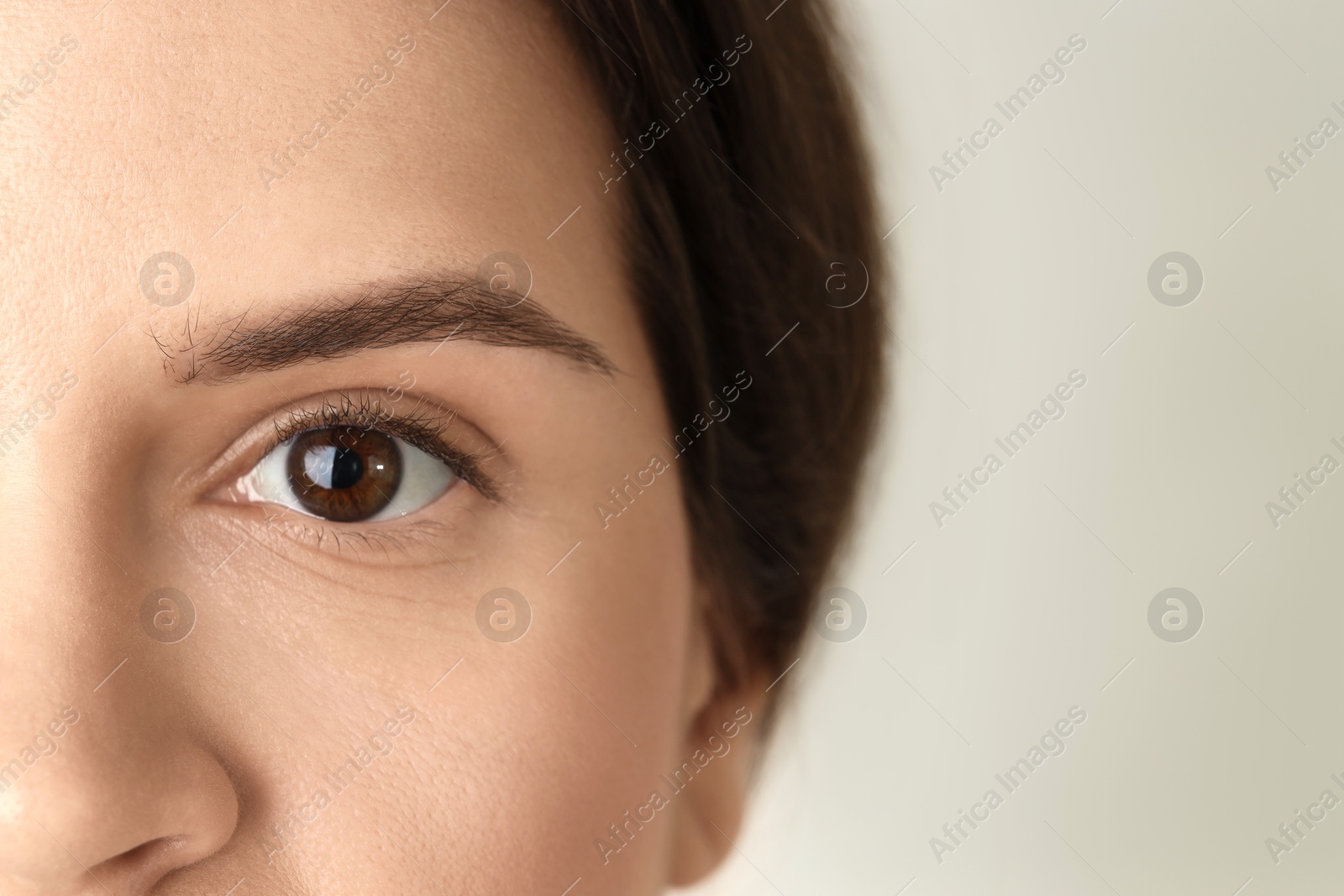 Photo of Woman with beautiful eyes on light background, closeup