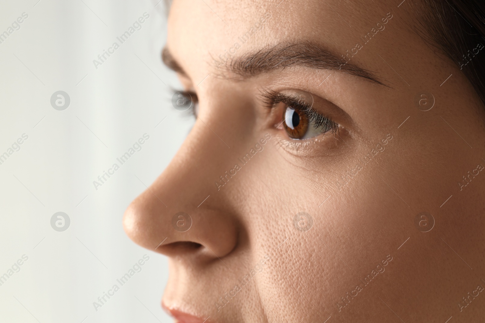 Photo of Woman with beautiful eyes on light background, closeup