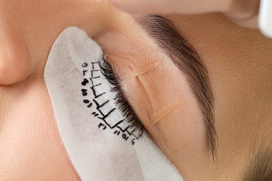 Woman with under eye patch mapped for lash extensions procedure, closeup