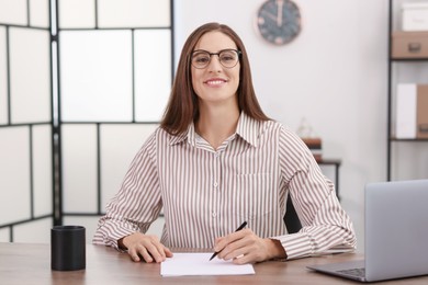 Photo of Banker working with document at wooden table in office