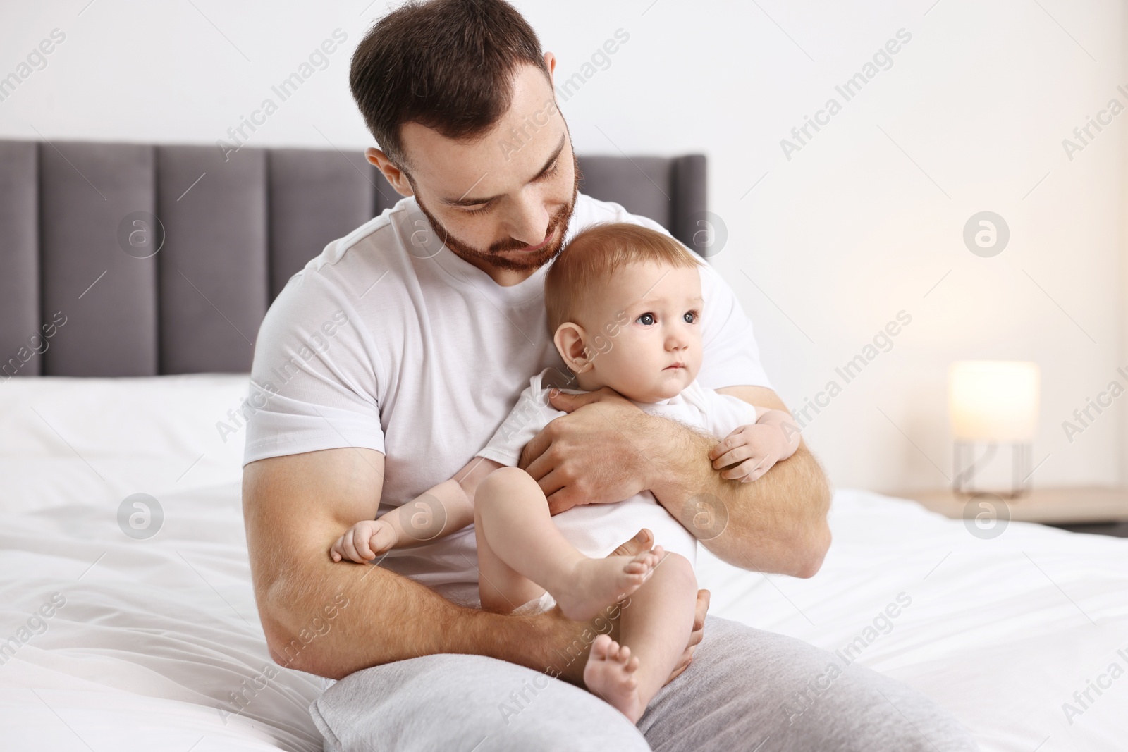 Photo of Father with his little baby on bed at home