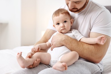 Photo of Father with his little baby on bed at home, closeup