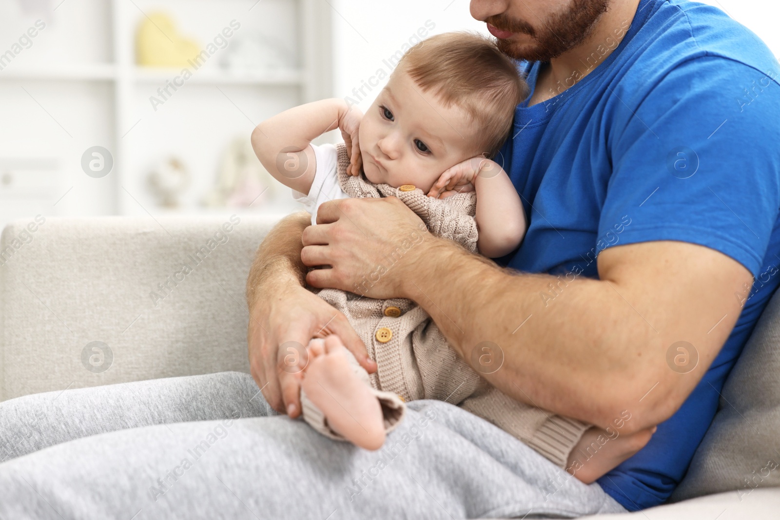 Photo of Father with his little baby on sofa at home, closeup