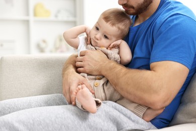 Photo of Father with his little baby on sofa at home, closeup