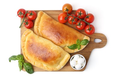 Photo of Tasty vegetarian calzones with basil, mozzarella cheese and tomatoes isolated on white, top view