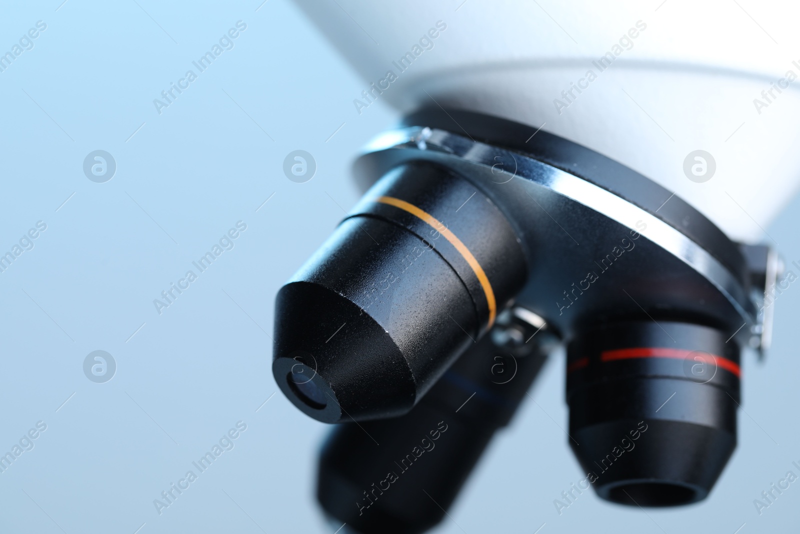 Photo of Science. Modern microscope on light blue background, closeup. Space for text