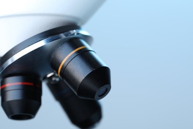 Photo of Science. Modern microscope on light blue background, closeup. Space for text