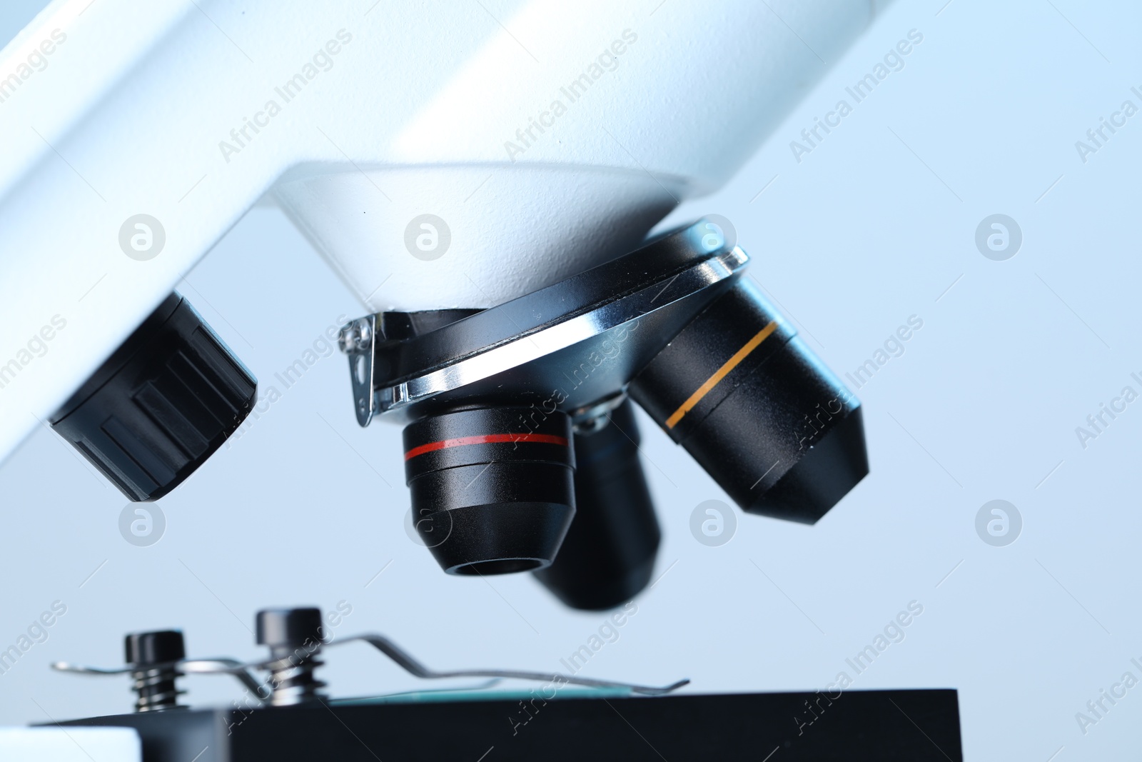 Photo of Science. Modern microscope on light blue background, closeup