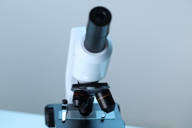 Photo of Science. Microscope with glass slide on blurred background, closeup