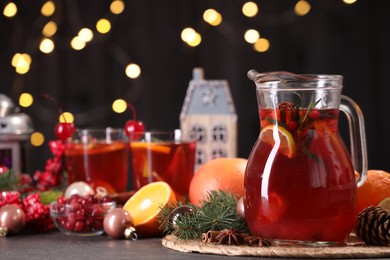 Photo of Tasty punch drink and Christmas decor on grey table