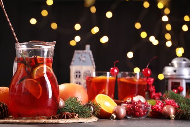 Photo of Tasty punch drink and Christmas decor on grey table