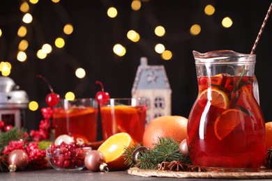 Photo of Tasty punch drink and Christmas decor on grey table