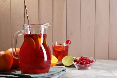 Photo of Tasty punch drink and ingredients on white table, space for text