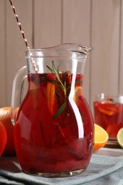 Photo of Tasty punch drink in glass jug on table, closeup